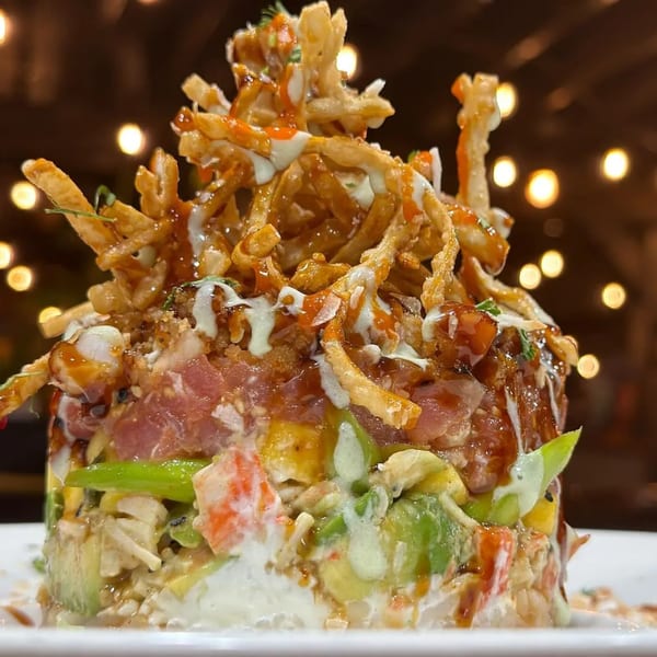 HOOKED seafood tower with tuna, avocado, and crispy toppings, drizzled with sauces.