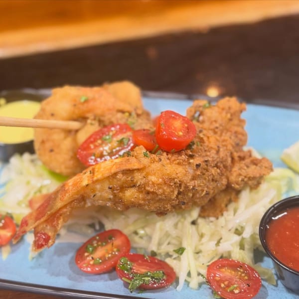 Crispy fried shrimp with cherry tomatoes and shredded lettuce, served with dipping sauces.